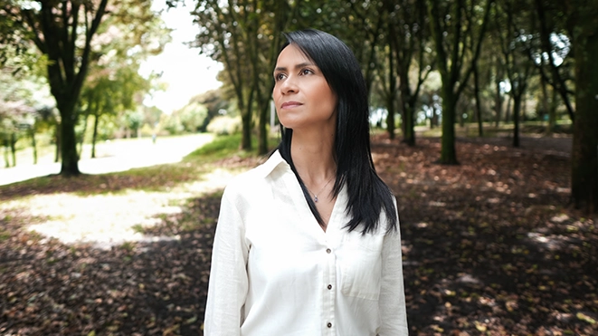 Paula Jiménez, hipnoterapeuta clínica, contemplando un horizonte natural, simbolizando la claridad mental y la paz interior lograda a través de la terapia.