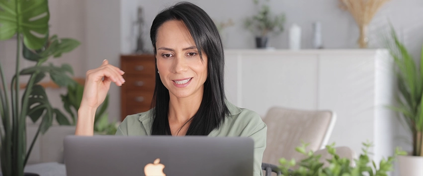 Paula Jimenez smiling while conducting a clinical therapeutic hypnosis session online via laptop.