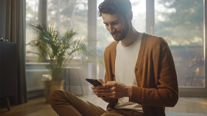 Man using his smartphone to make the initial contact and start his emotional change process.