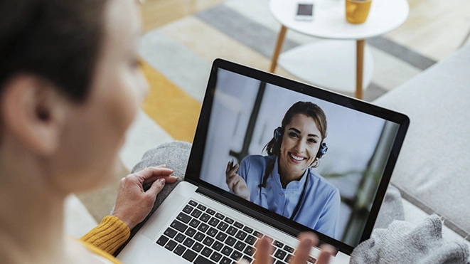 Woman smiling during a free online discovery video call for clinical hypnotherapy.