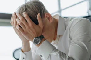 Man holding his face showing feeling stuck in life and emotional overload despite ongoing effort